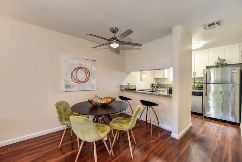 Model home dining area with a ceiling fan over the table. Area has an open concept feel where you can view kitchen from the dining area. Model home dining area with a ceiling fan over the table. Area has an open concept feel where you can view kitchen from the dining area. at Monte Bello Apartments, California, 95826 - Photo Gallery