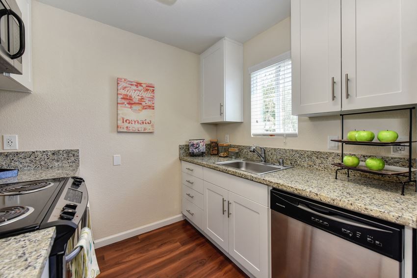 Kitchen with Granite Counters, white cabinets, window above the sink area and stainless dishwasher Kitchen with Granite Counters, white cabinets, window above the sink area and stainless dishwasher at Monte Bello Apartments, Sacramento, CA, 95826 - Photo Gallery