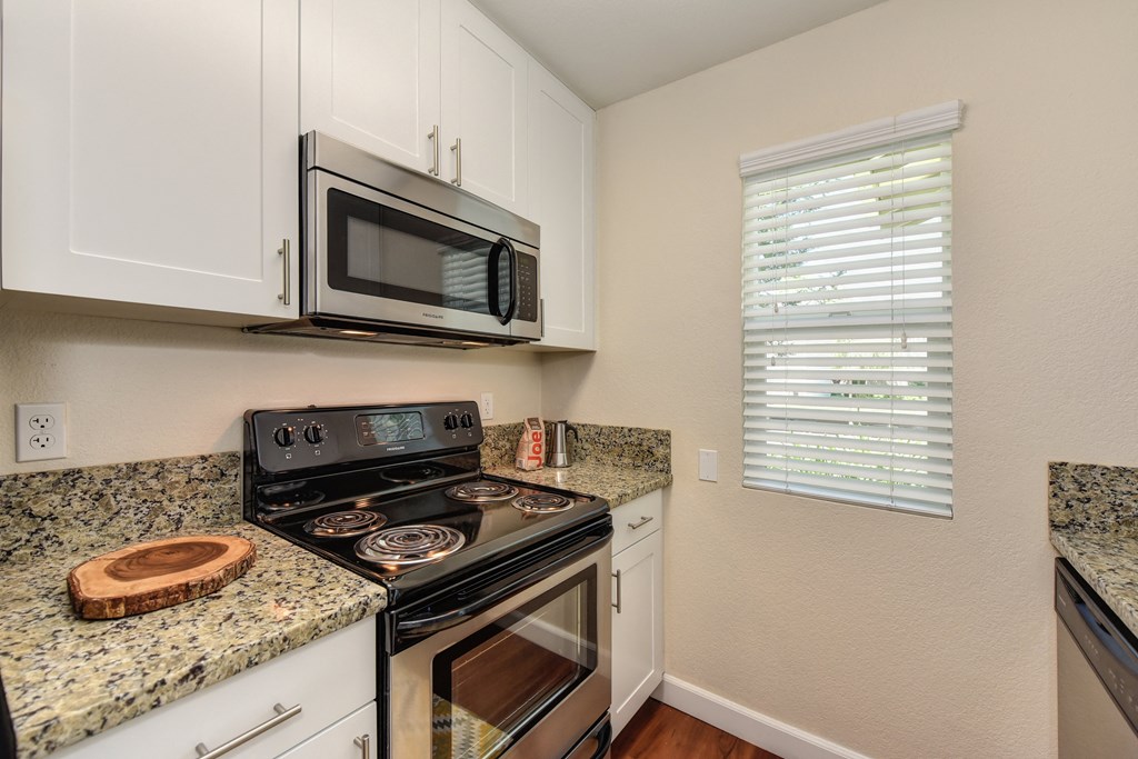 Kitchen with Granite Counters, Hardwood Inspired Floors, Microwave and Oven at Monte Bello Apartments, Sacramento ,95826