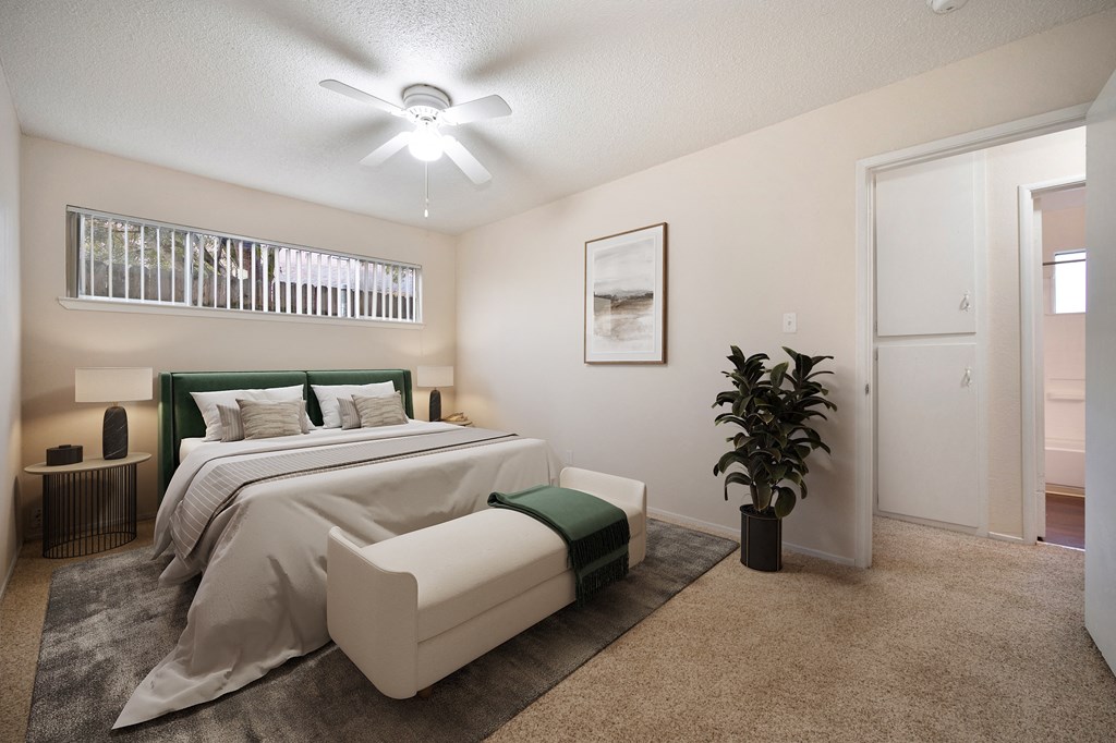 A bedroom with a large bed and a ceiling fan.