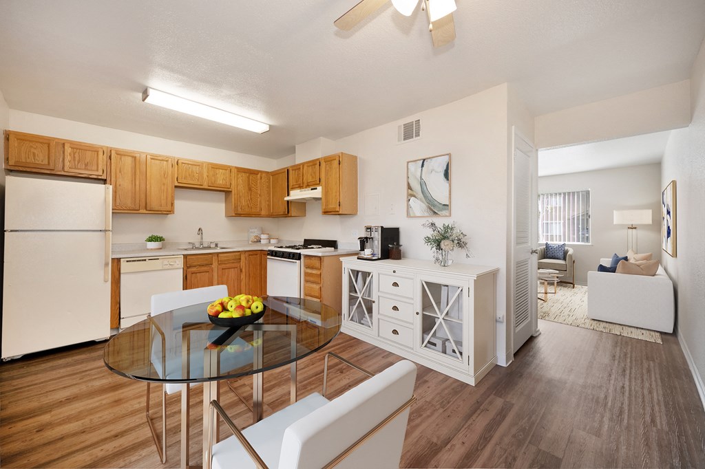 A modern kitchen with wooden cabinets and a glass table.