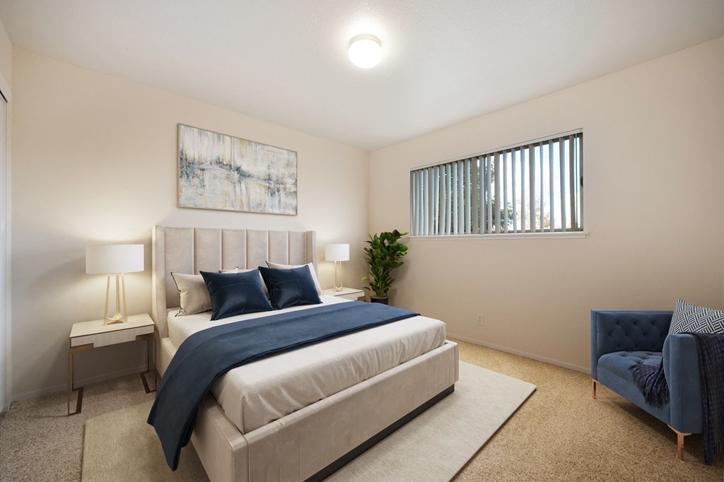 A bedroom with a large bed and a blue chair.
