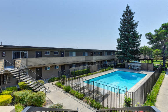 Outdoor Swimming Pool, Trees, Bushes and Apartment Exteriors  at Olympus Park Apartments, Roseville, CA, 95661