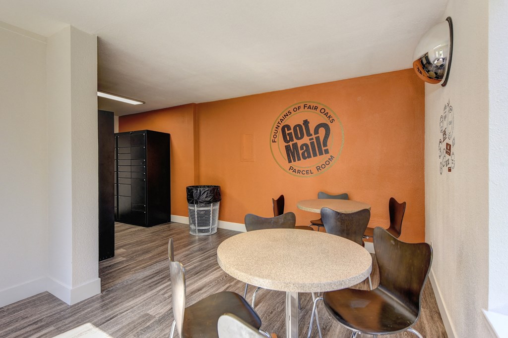 Parcel Room with Hardwood Inspired Floor, Short Round Tables, Chairs, Orange Wall with at Fountains of Fair Oaks, California, 95628