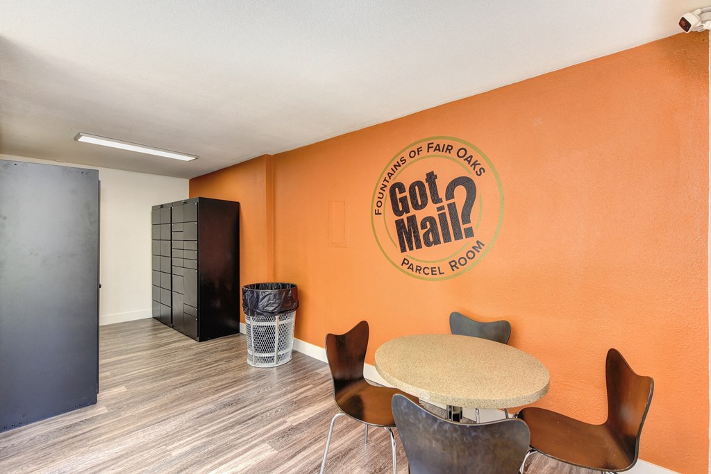 Parcel Room with Hardwood Inspired Floor, Short Round Tables, Chairs, Orange Wall with at Fountains of Fair Oaks, California