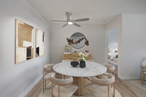 A dining room with a round table and chairs.