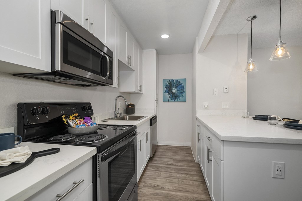 a kitchen with white cabinets and a black stove top oven