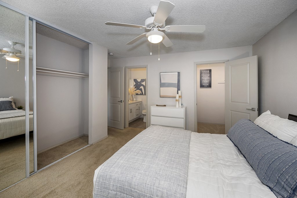 a bedroom with a bed and a ceiling fan