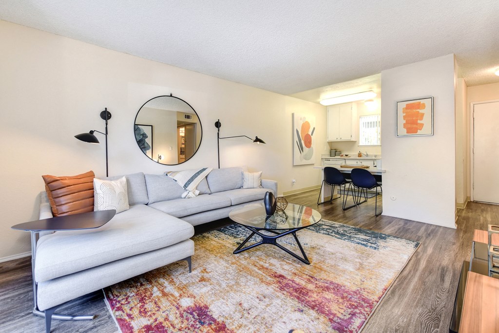 a living room with a couch table and chairs and a kitchen in the background at Renaissance Park Apartments, California