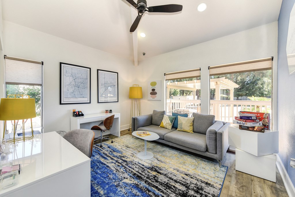 a living room with a gray couch and a blue rug at Renaissance Park Apartments, Davis, CA