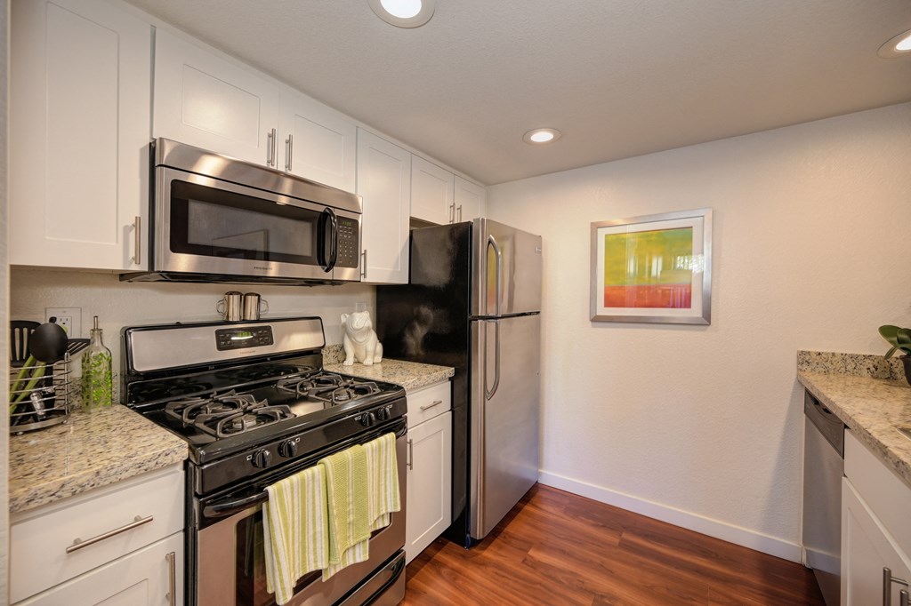 Kitchen Stove with Refrigerator, Hardwood Inspired Floor  and Microwave at Rocklin Manor  Apartments, California, 95677