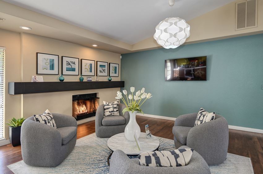 Leasing Office sitting area with flat screen tv on the call and fireplace with black mantle. - Photo Gallery 1