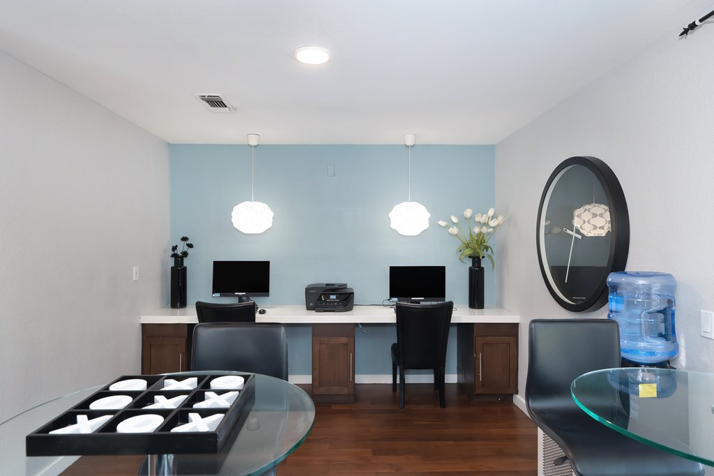 A modern home office with a glass table and a glass top coffee table.