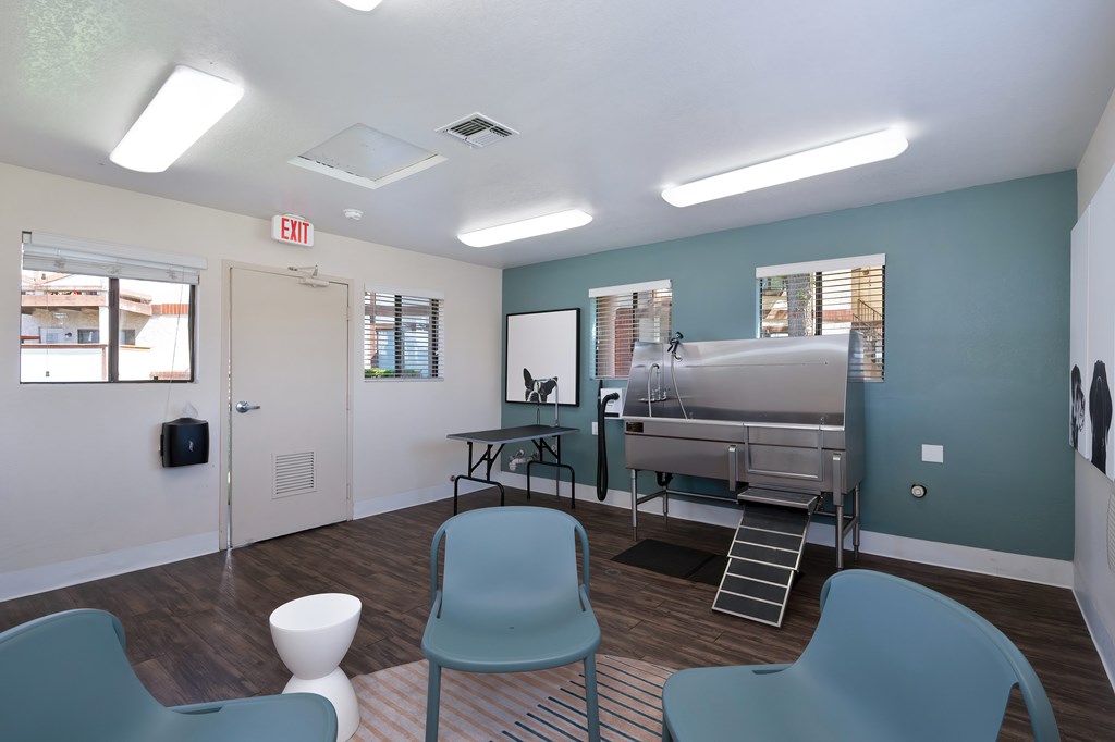A room with a blue chair and a white stool.