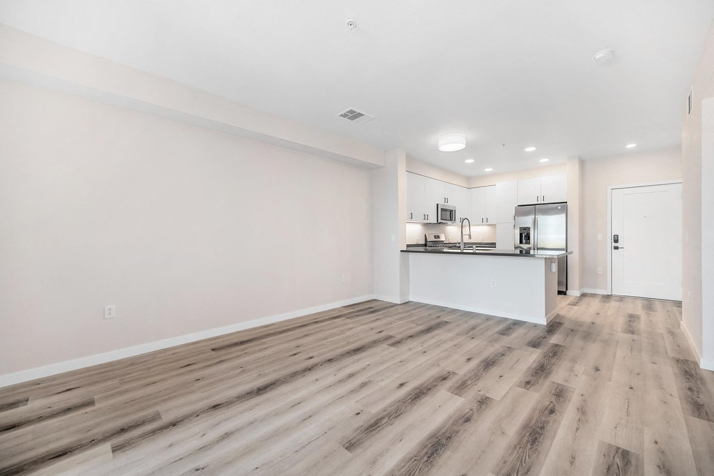a living room with white walls and hardwood inspired floors at Sierra Gateway Apartments, Rocklin, CA
