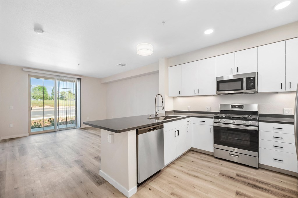 an empty kitchen with white cabinets and stainless steel appliances at Sierra Gateway Apartments, Rocklin