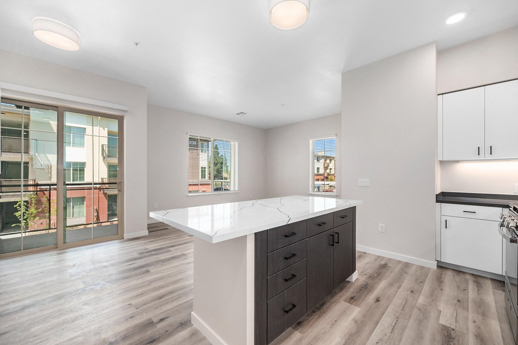 an open kitchen with white countertops and a large island at Sierra Gateway Apartments, Rocklin, 95677
