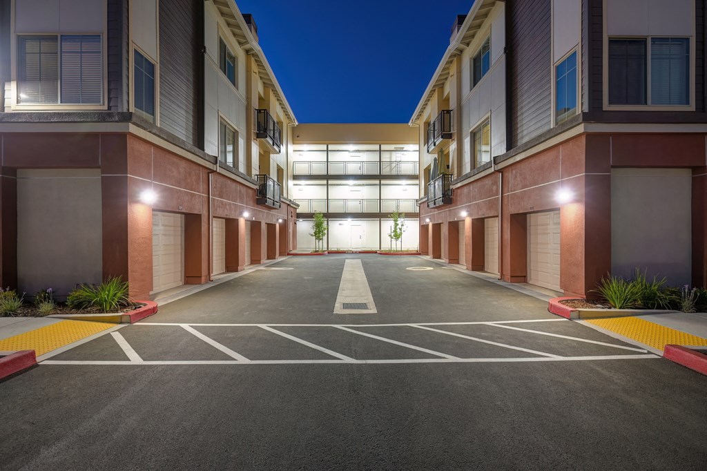 an empty parking lot in front of an apartment building at night at Sierra Gateway Apartments, Rocklin, California