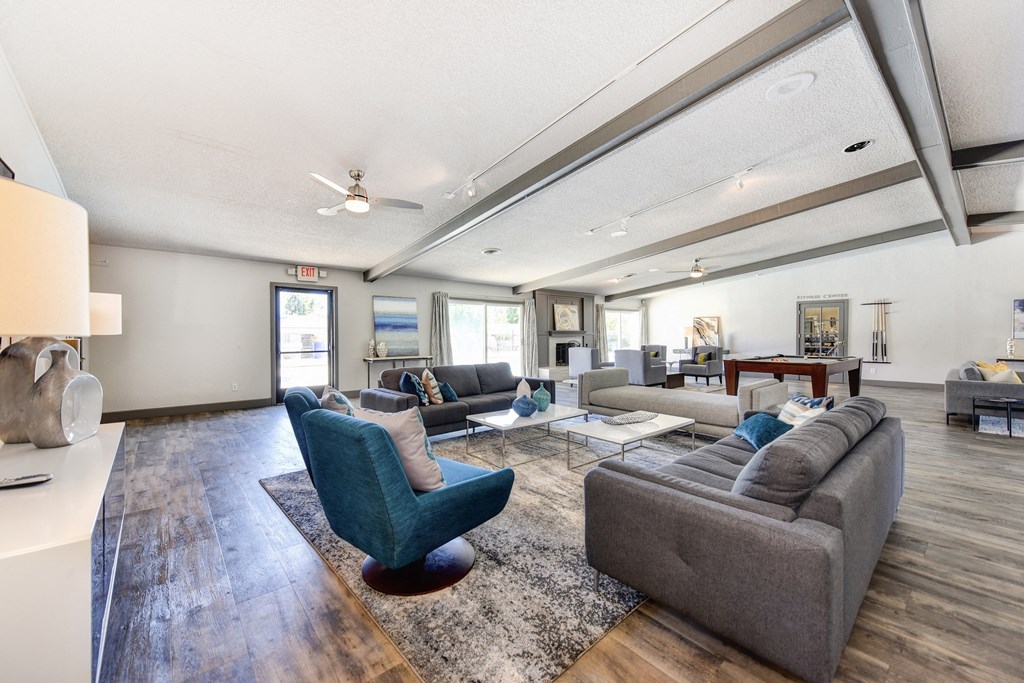 Clubhouse Sitting Area with Hardwood Inspired Floor, Gray Sofa, Rug and Ceiling Fan/Light at The Renaissance Apartments, Citrus Heights