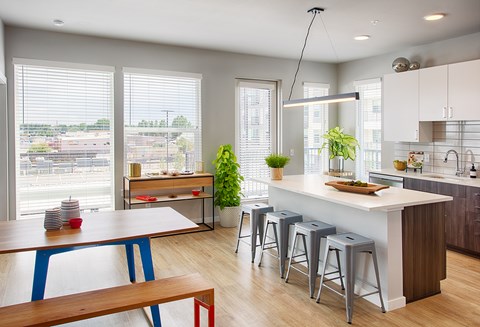 A kitchen with a table and bar stools.