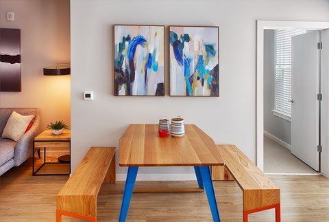 A modern dining room with a wooden table and benches.