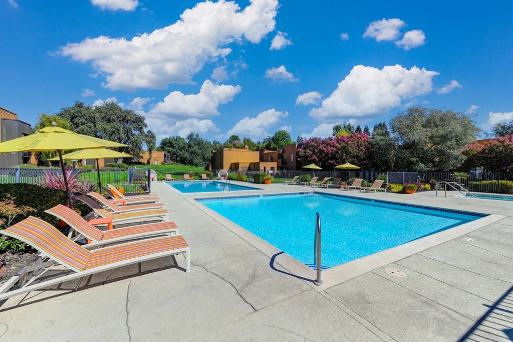 Pool Area with Yellow Umbrellas, Lounge Chairs, and sparking bluePool at Fountains of Fair Oaks, Fair Oaks California