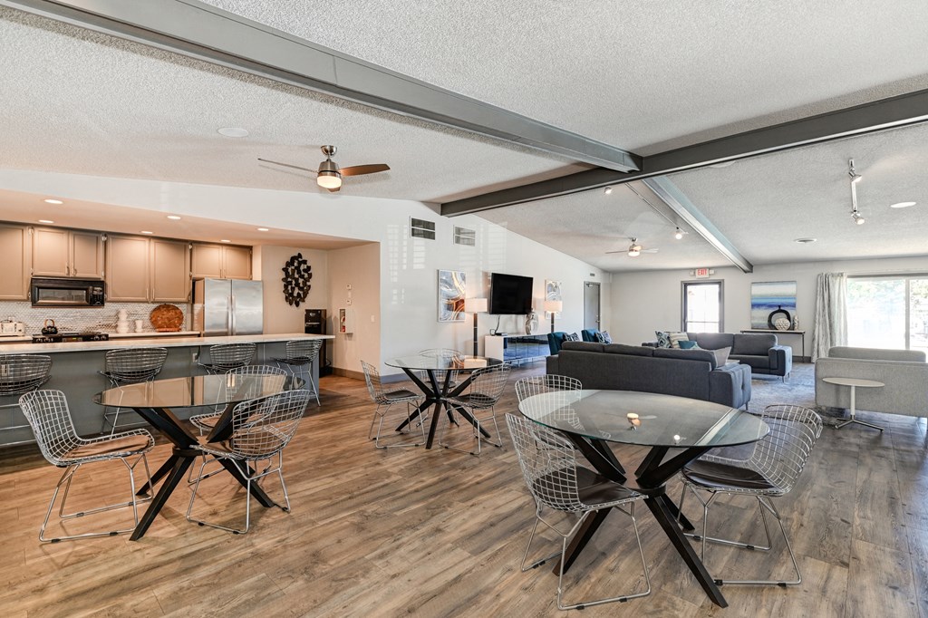 Community clubhouse with Hardwood Inspired Floors, and numerous seating areas and tables.at The Renaissance Apartments, Citrus Heights