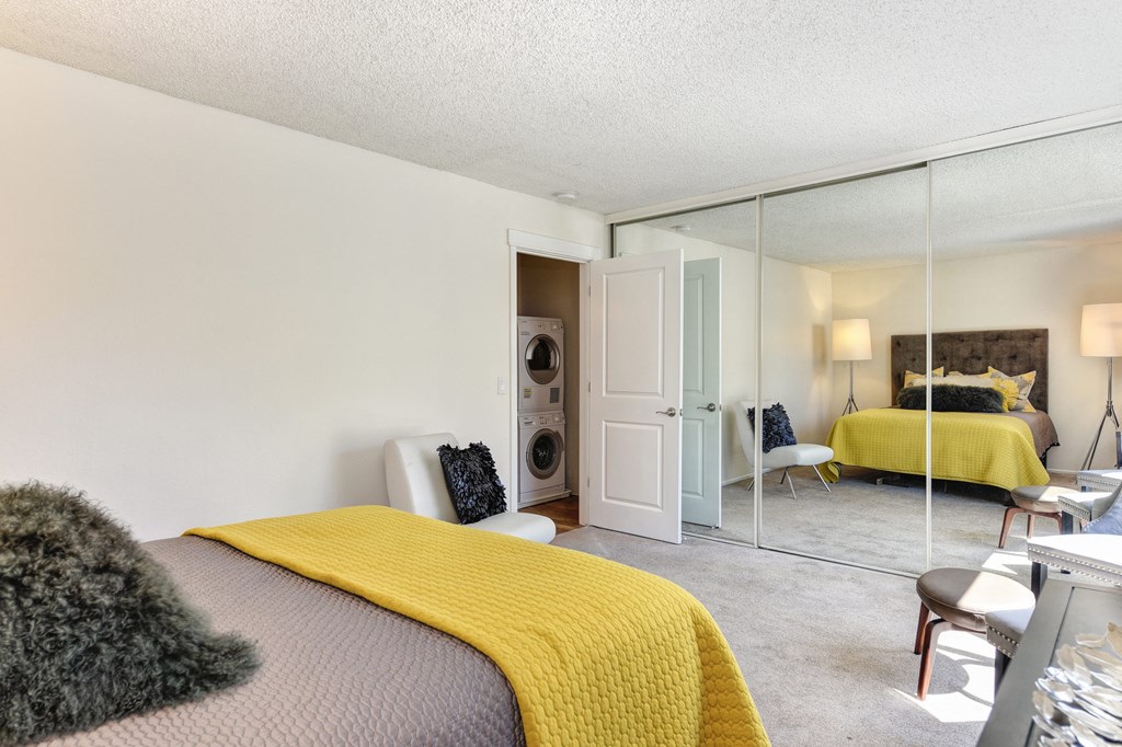 a bedroom with a bed and a mirrored closet doors