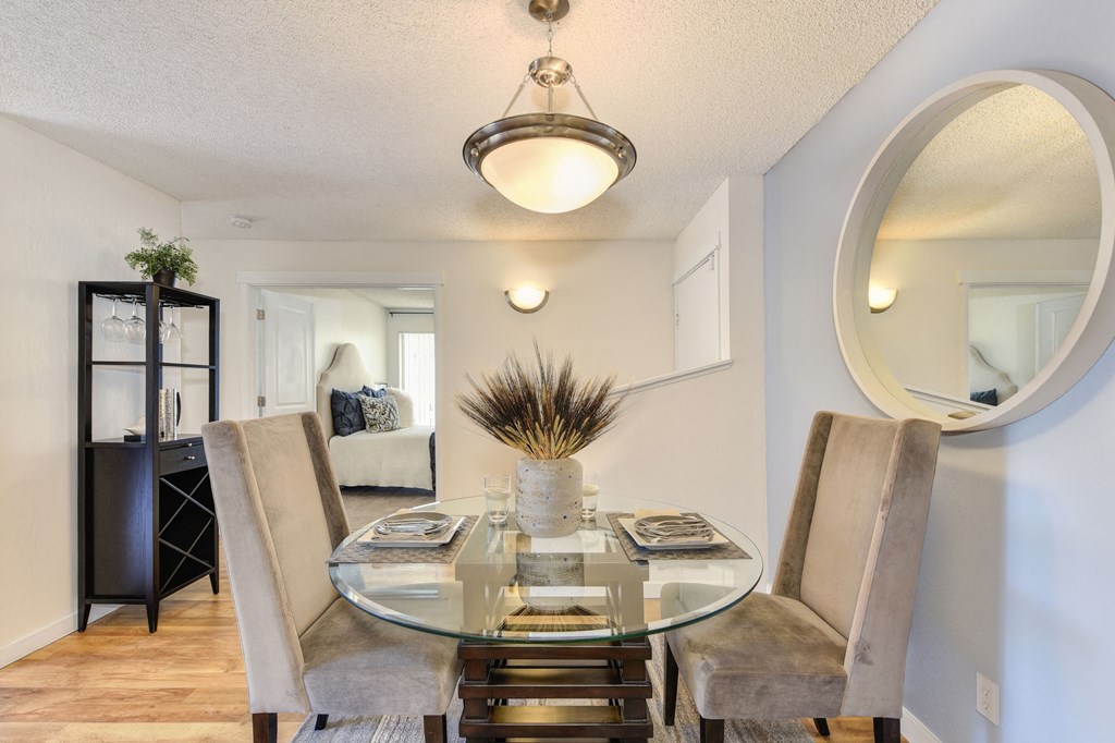 a dining room with a glass table and chairs