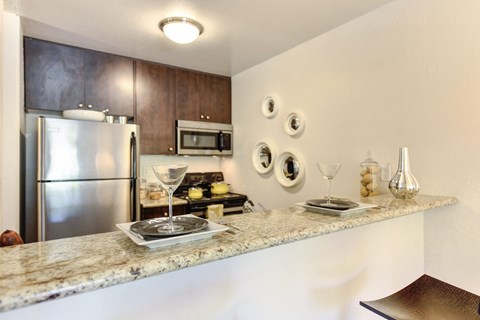 a kitchen with a granite counter top and a stainless steel refrigerator