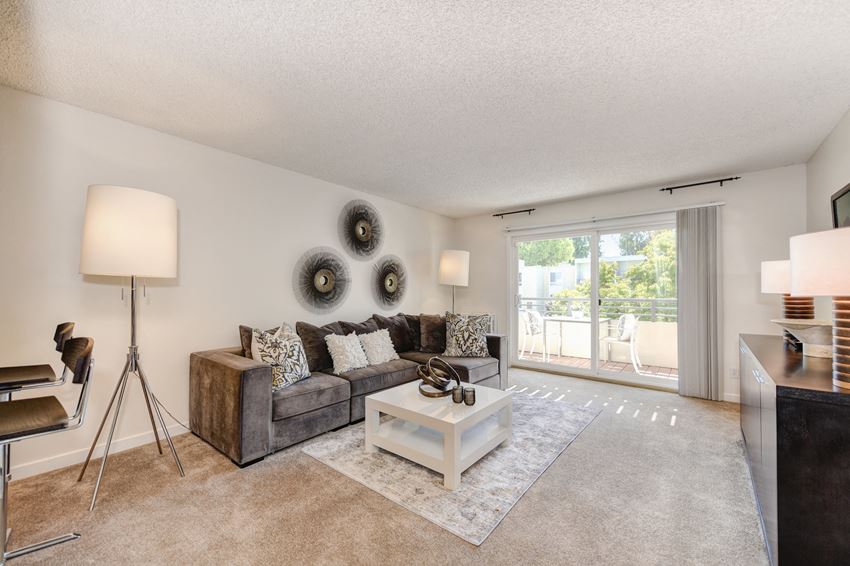 a living room with a couch coffee table and a sliding glass door a living room with a couch coffee table and a sliding glass door at The Retreat at Walnut Creek, Walnut Creek