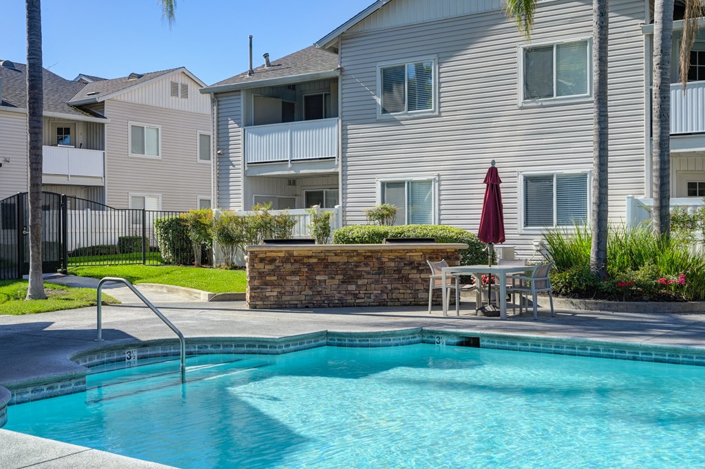 The Legacy Apartments swimming pool with Gas BBq's and tables and chairs around the pool at The Legacy Apartments, Antelope, CA, 95843