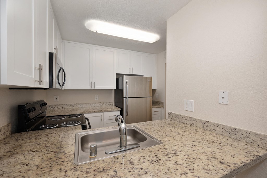 a kitchen with granite counter tops and a stainless steel refrigerator at Rush River Apartments, Sacramento, 95831