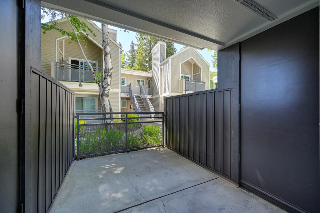 the entrance to the patio of an apartment building with a ramp to the sidewalk at Rush River Apartments, Sacramento, CA, 95831