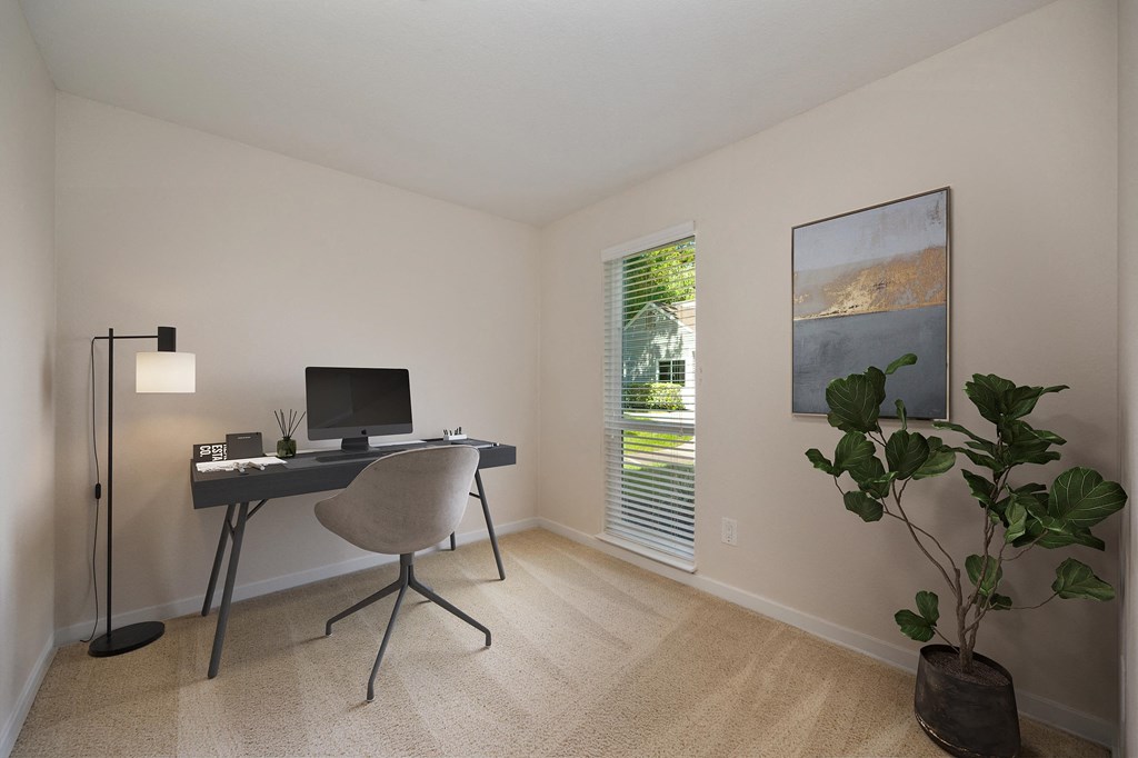 a home office with a computer desk and a plant in a room with a window at Rush River Apartments, Sacramento, 95831