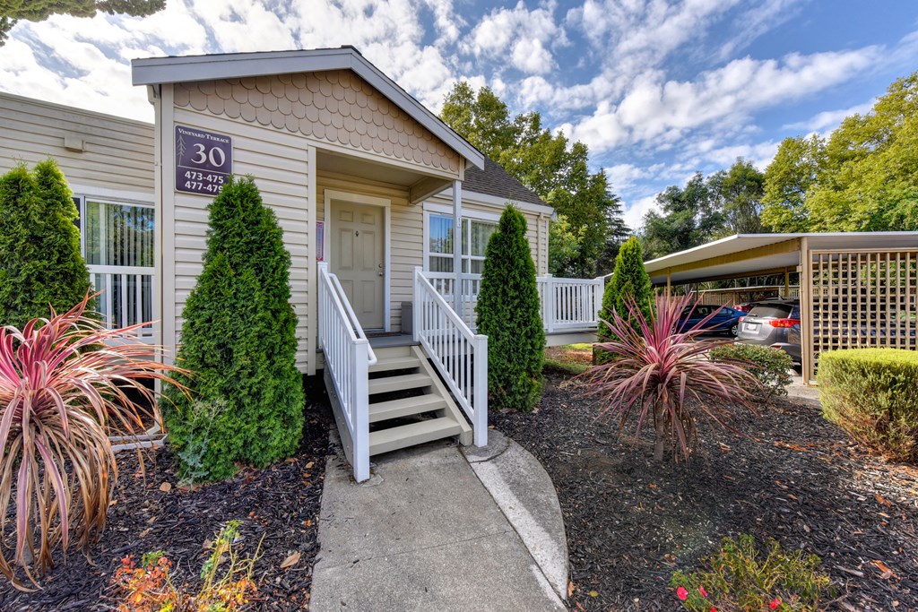 Apartment entrance with small staircase leading up to the front of the building at Vineyard Terrace Apartments, California