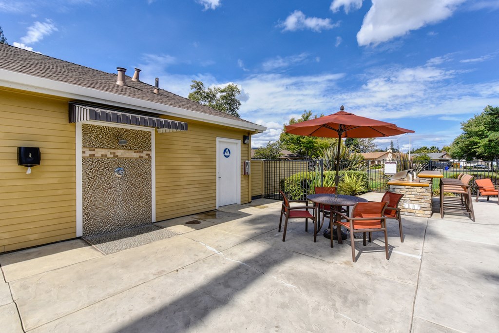 Pool area bathrooms and tables and chairs at Vineyard Terrace Apartments, California