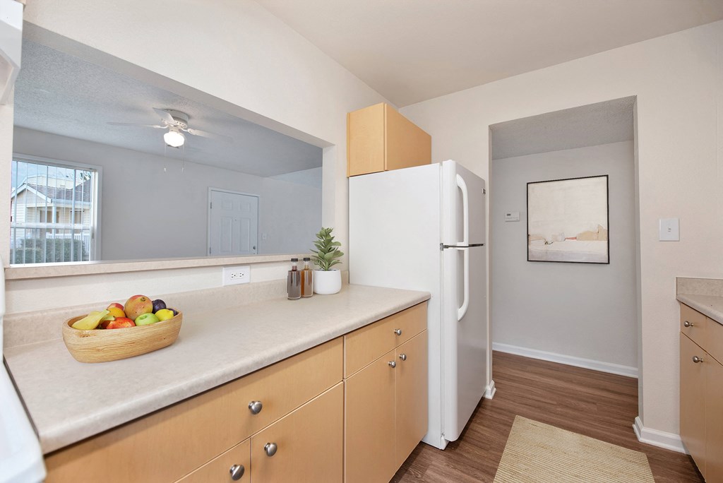 a kitchen with a white refrigerator and a basket of fruit at Vineyard Terrace Apartments, California