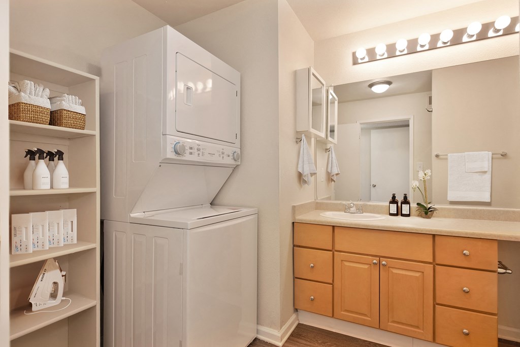 a bathroom with a washer and dryer and a sink and a mirror at Vineyard Terrace Apartments, Napa, 94558