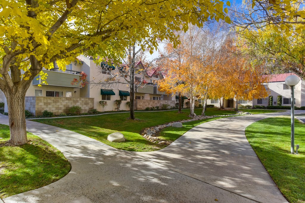 a pathway through the West Oaks community with trees and Apartment buildings in the background