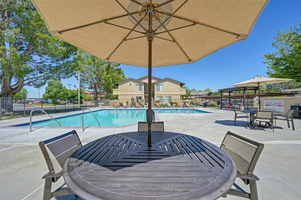 our apartments have a swimming pool and a patio with a table and chairs