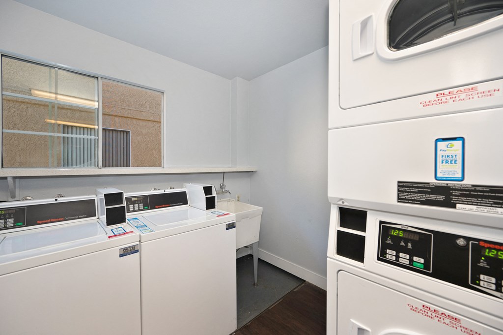 a laundry room with two washing machines and a sink