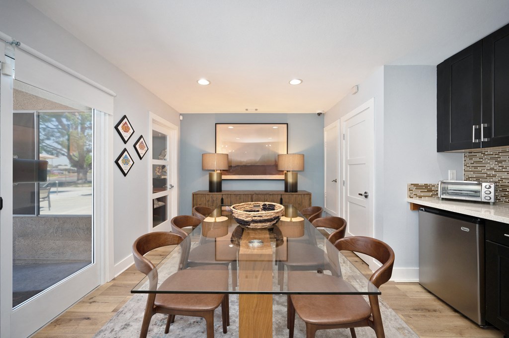 a dining room with a glass table and chairs