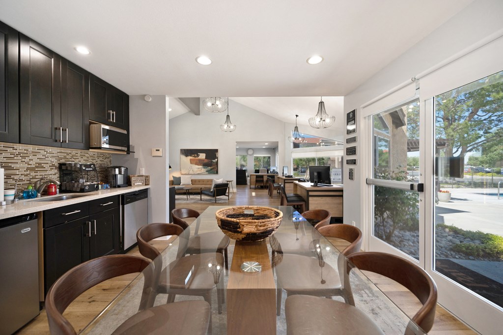 a kitchen and dining room with a glass table and chairs