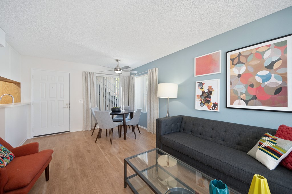a living room and dining room with a couch and a glass table