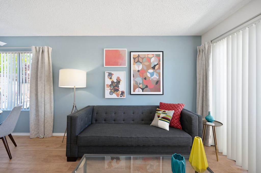 a living room with blue walls and a black couch