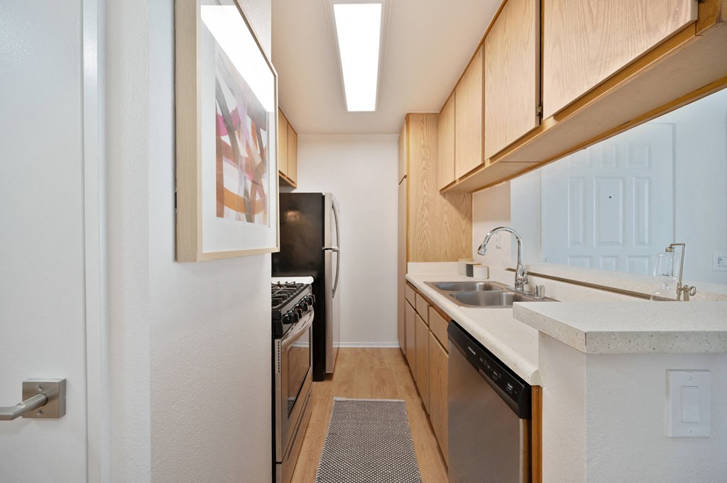 a kitchen with wooden cabinets and a sink and a refrigerator