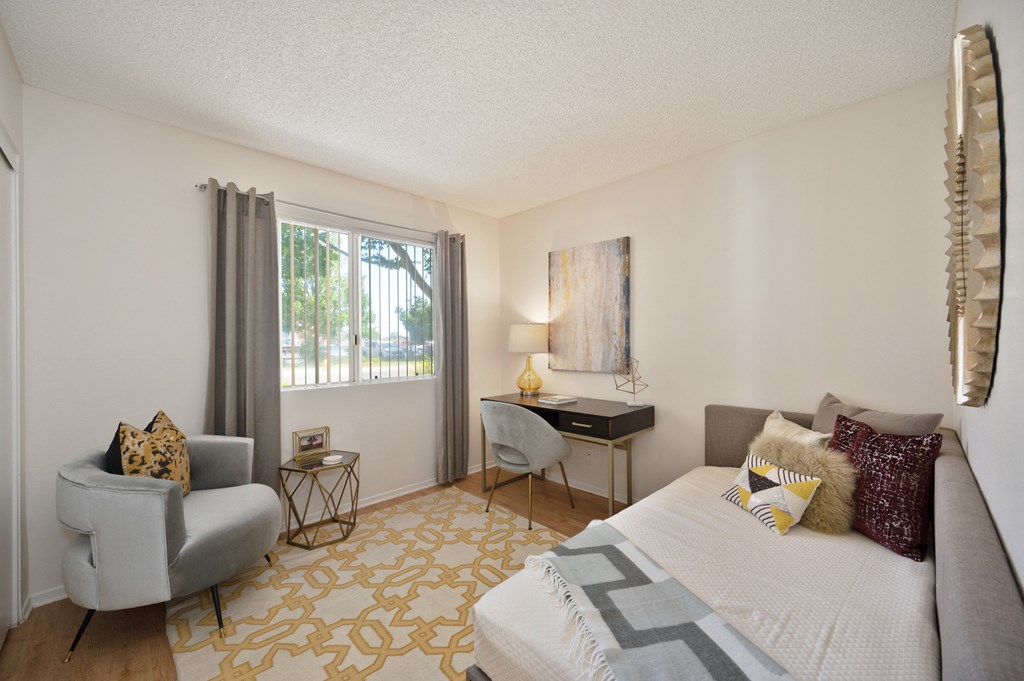 a bedroom with a bed and a chair and a desk