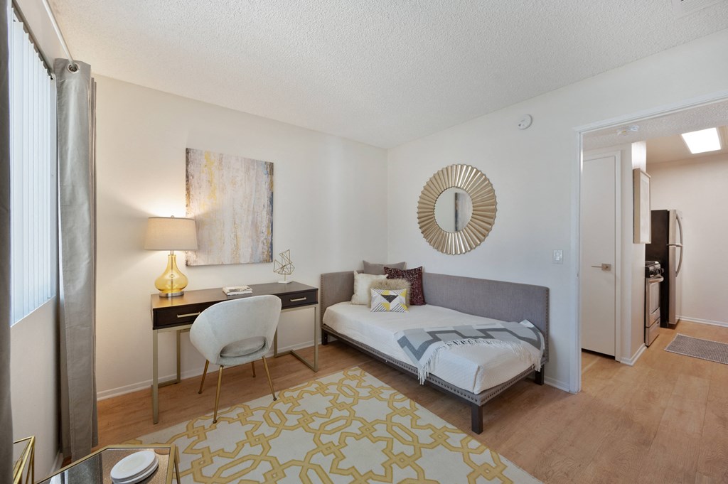 a bedroom with a bed and a desk with a chair