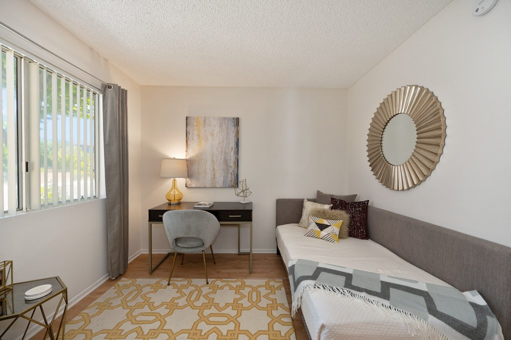 a bedroom with a bed and a desk with a chair